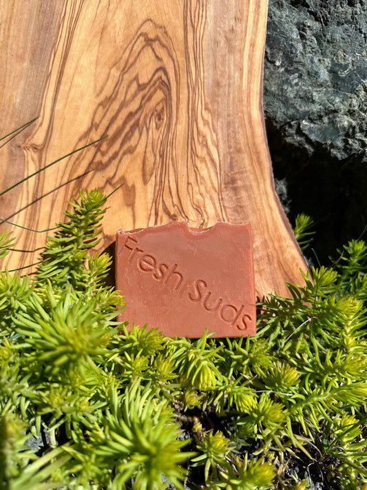 Warm Sauna soap bar, featuring a rich blend of iris, violet, jasmine and citrus, enriched with French Red clay, capturing the essence of a soothing sauna experience in a luxurious cleansing bar.