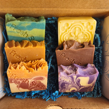Build Your Own box of six handmade soap bars in assorted colours on blue paper shred