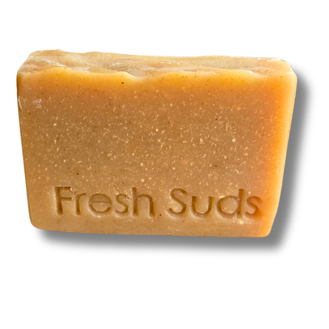 Restore Dandelion soap bar, golden, resting on a stone ledge