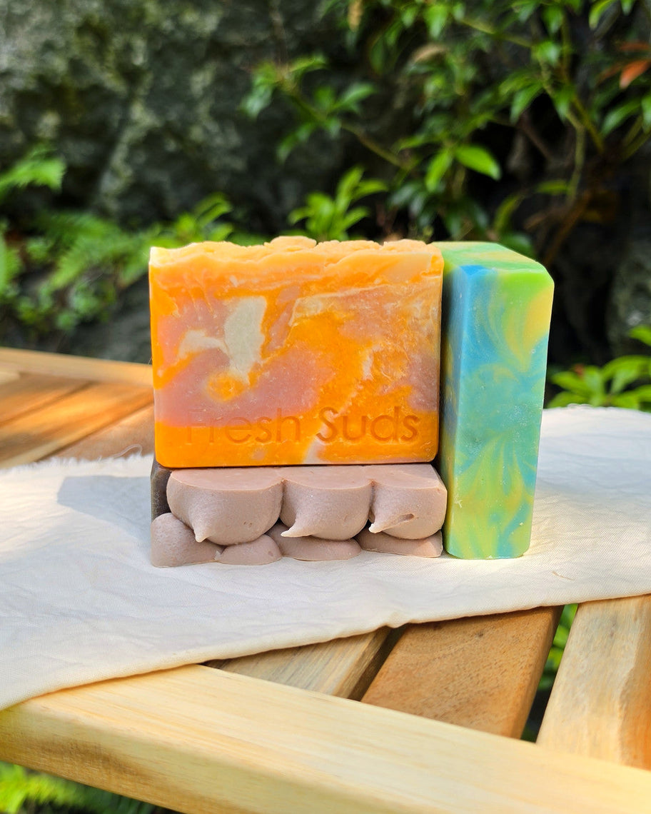 Slice of Summer bars stacked on cream linen with ferns — Golden Plumeria, Candy Floss and Picnic