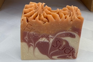 A Fresh Suds Mango Surprise bar — hand-piped peaks on top, mauve and cream swirl through the base, 'Fresh Suds' stamped into the side. Real handmade soap, not factory-molded.