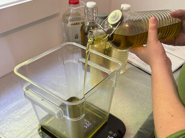 Olive oil being poured onto the scale for a fresh batch of Fresh Suds soap in the Chilliwack studio.