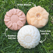 3 flower shaped salt soap bars on a grassy background. Fresh Suds Soapery
