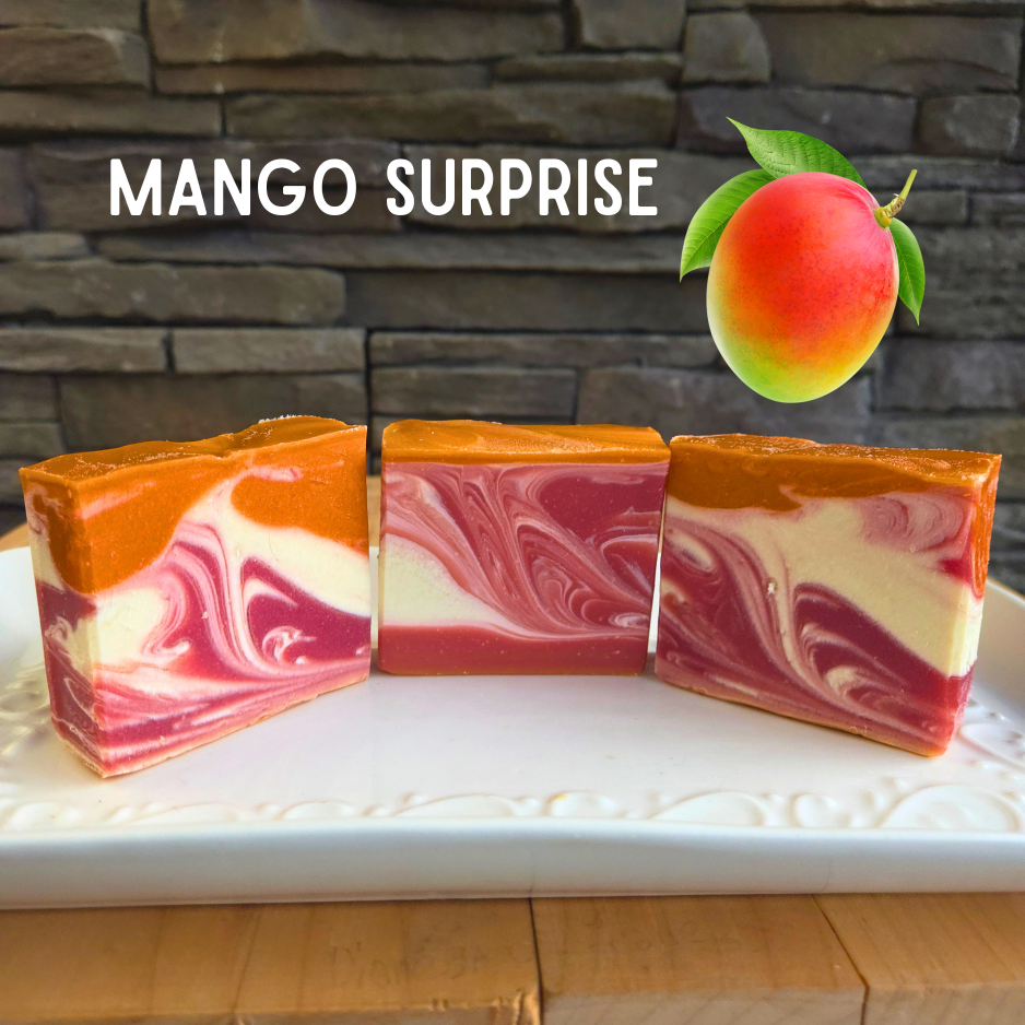 Three Mango Surprise soap bars with a stone wall background
