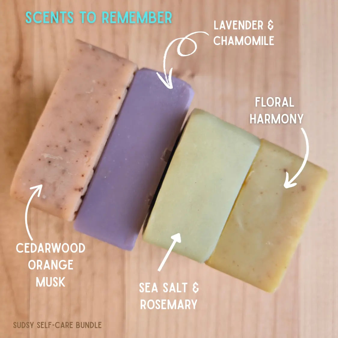 Four bars of soap with labeled scents on a wooden surface