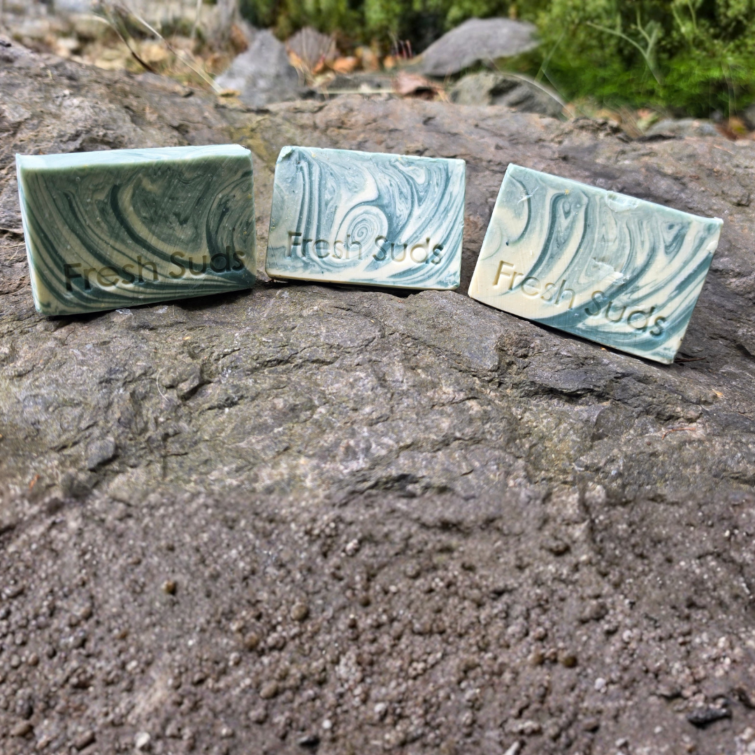 Three Glacier Arctic Mineral Clay bars stacked on rock